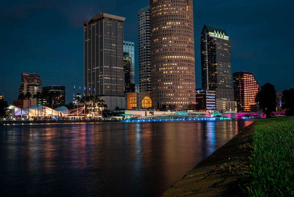 Downtown Tampa skyline across the river at blue hour, city lights reflected in the water