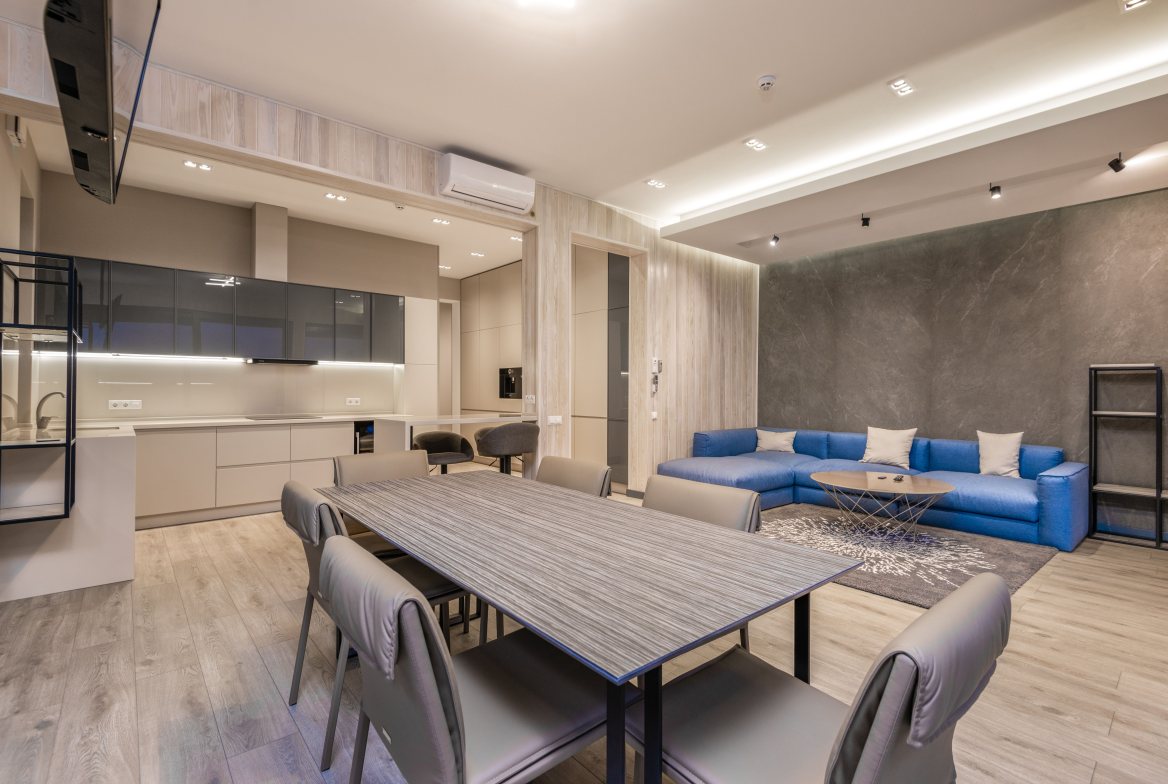 An open living and dining space with a long table and a blue sectional