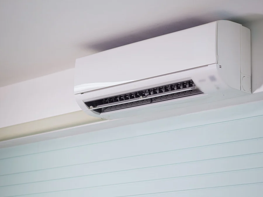 A white ductless mini-split unit mounted high on a wall
