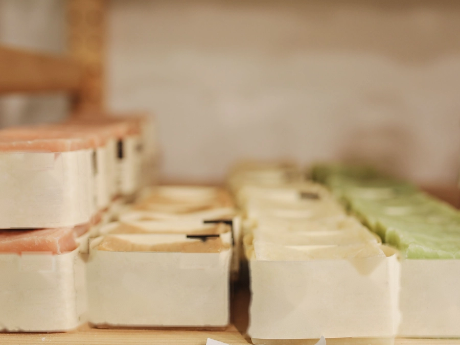 Bars of handmade soap wrapped in paper on a shop shelf
