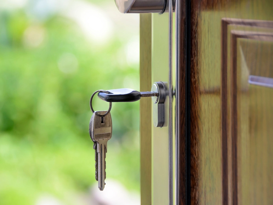 A set of keys in the lock of an open door