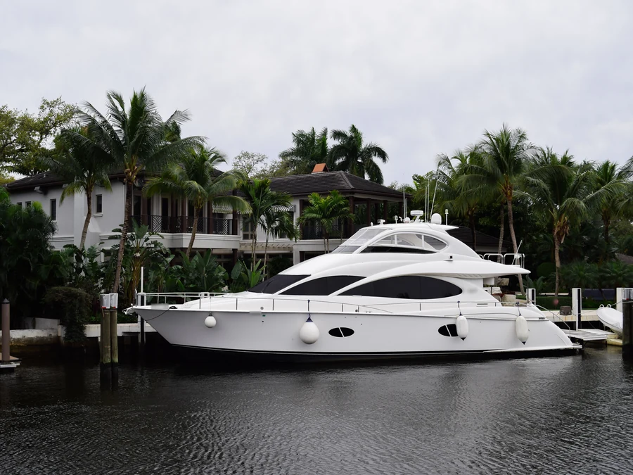 White motor yacht with a glossy hull at a canal-side dock